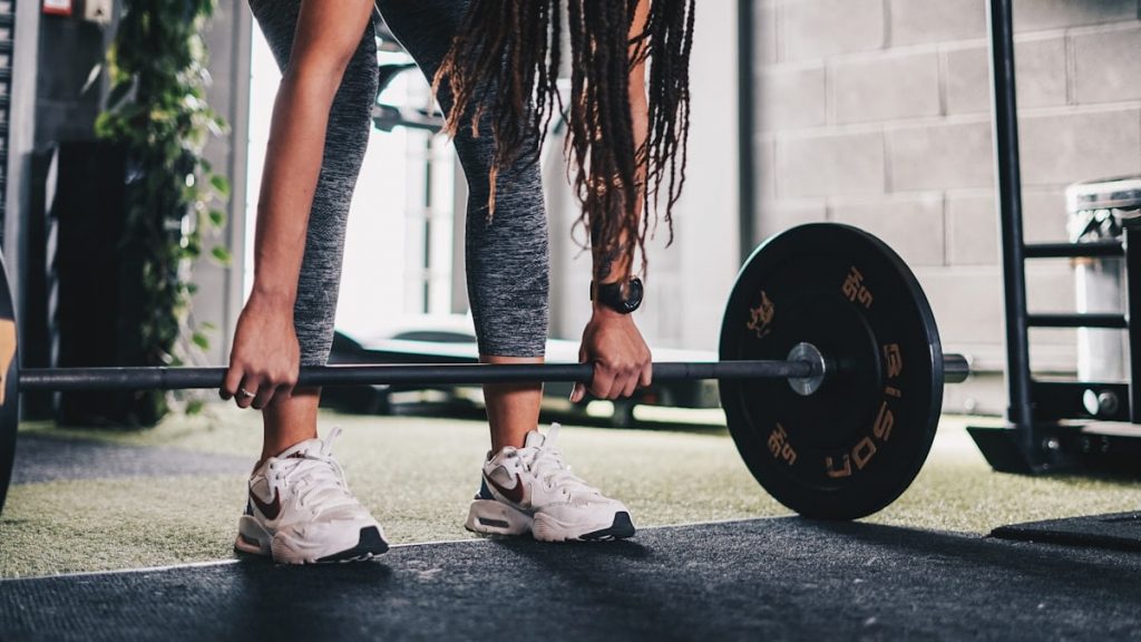 a woman lifting a barbell in a gym
